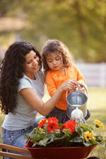 Mother and daughter watering plants