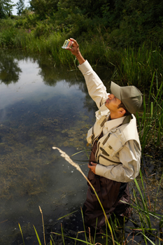 Scientist testing water outdoors.