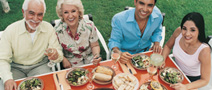 photo of a group of people sitting around a table full of food