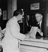 J.N. "Ding" Darling with a sheet of the first Federal Duck Stamps (1934). USFWS/Smithsonian Institute