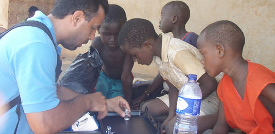 Brazilian FETP trainee, Jean Barrado, R.N., is surrounded by curious children while conducting drinking water tests.