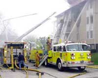 (Fig. 2.1) Good aerial apparatus access at an apartment fire.  This fire lane is wide enough to allow passing even when aerial outriggers are extended, and it is located a proper distance from the building to facilitate aerial operations.