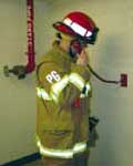 (Fig. 6.8b) A firefighter using a handset in a remote jack located inside a stairway.