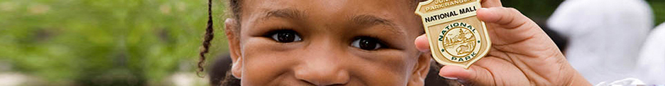 image of a child holding a junior ranger badge