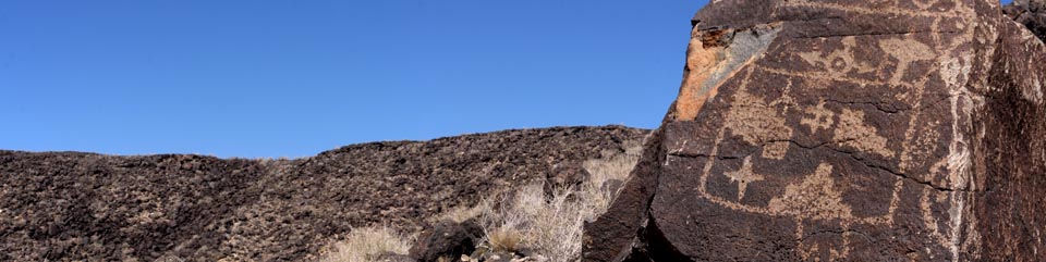 Petroglyphs and volcanic escarpment view from the Mesa Point trail at Boca Negra Canyon.