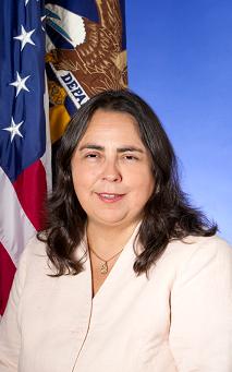 An image of Assistant Secretary Kathleen Martinez with the American and Department of Labor flags behind her.