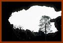 Looking through a cave opening at the sky outside.