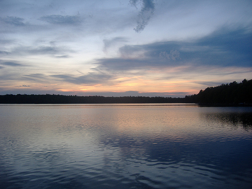 A striking sunset crowns the trees surrounding this northern Wisconsin lake, whose impacts from climate change are reflected in the blog by Leslie Brandt, US Forest Service, below." 