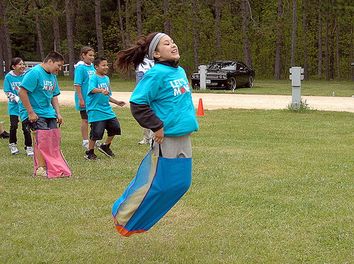 A Menominee girl enjoys the sackrace fun with her classmate friends.