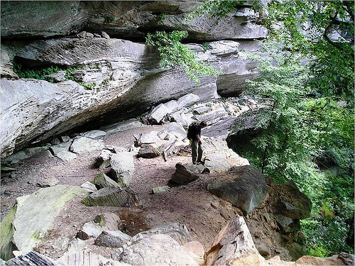 A hiker explores a rock shelter in the Red River Gorge (photo courtesy of Daniel Boone National Forest).