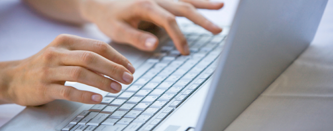 hands typing on a computer keyboard