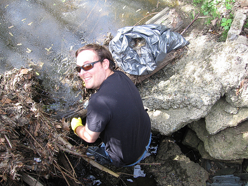 Working as an Earth Team volunteer, Cartographic Technician Jonathan Bowlin pulls trash from a stream near his office in Greensboro, N.C.