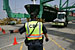 A CBP Officer directs a truck with a seaport container to an inspection area at a port.