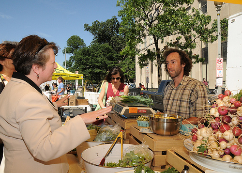 Agriculture Deputy Secretary Kathleen Merrigan wishes a vendor at the  Freshfarm Market on Vermont in Washington, D. C.,  Avenue by the White House good luck on his sales