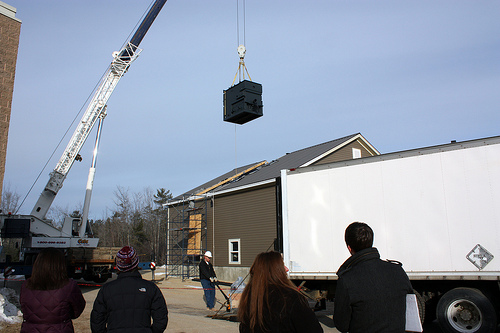 Maine Fuels for Schools. The firebox for Poland Regional High School's new Recovery Act-funded biomass heat system is hoisted into the boiler house, as school Principal Cari Medd (hat) and guests look on.