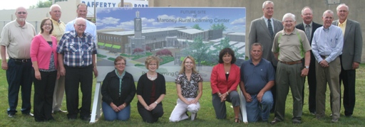 USDA and local officials in front of a rendering of the newly designed learning facility.