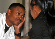 Man and woman at a relationship retreat sit by a window talking and smiling