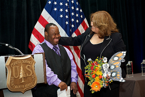 Receiving the award for “Communities in Conservation” are Luisa Lopez, Counselor at El Valor and Vincent Jordan, participant in El Valor's Adults with Different Abilities Program. They are holding one of the products of this program—a monarch butterfly made for Día de los Muertos, or Day of the Dead.