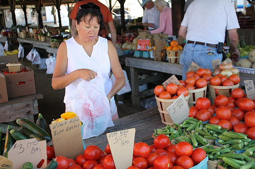 A vendor places tomatoes into a plastic bag for a customer at a Maryland farmers market.  Many beginning producers use farmers markets as the gateway to direct marketing opportunities. Photo by Elvert Barnes