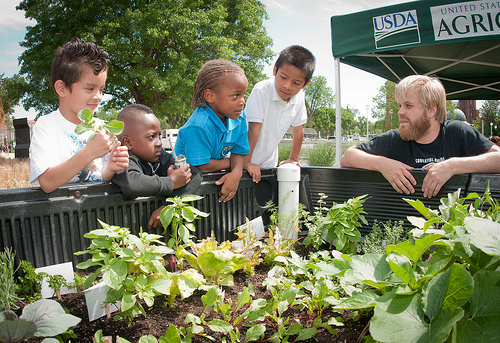 Stephen Kendall, Food Donations Coordinator at DC Central Kitchen, and students from Powell Elementary School in NW, DC hunt for  herbs in the Truck Farm during the USDA Farmers Market and the official kick off of the People's Garden Friday activities on Friday, June 3, 2011 in Washington, DC.