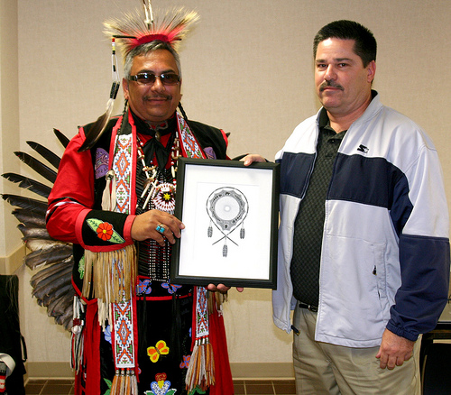 Left to right guest speaker Dr. James E. Pete and Rural Business Specialist Ken Lynch presenting Dr. Pete with one of his drawings.