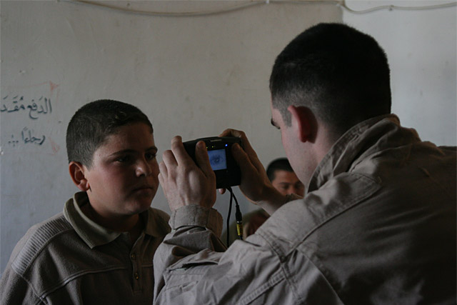 U.S. Marine Corps Lance Cpl. Kenneth L. Stoots, right, assigned to 2nd Squad, 2nd Platoon, Kilo Company, 3rd Battalion, 5th Marine Regiment, Regimental Combat Team 1, scans the retina of an Iraqi boy using the biometric automated toolset (BAT) in the Maulimeen district of Fallujah, Iraq, Feb. 14, 2008. The purpose of the operation is to enter citizens of Fallujah into the BAT system to provide them with identification cards. (U.S. Marine Corps photo by Cpl. William J. Faffler/Released)