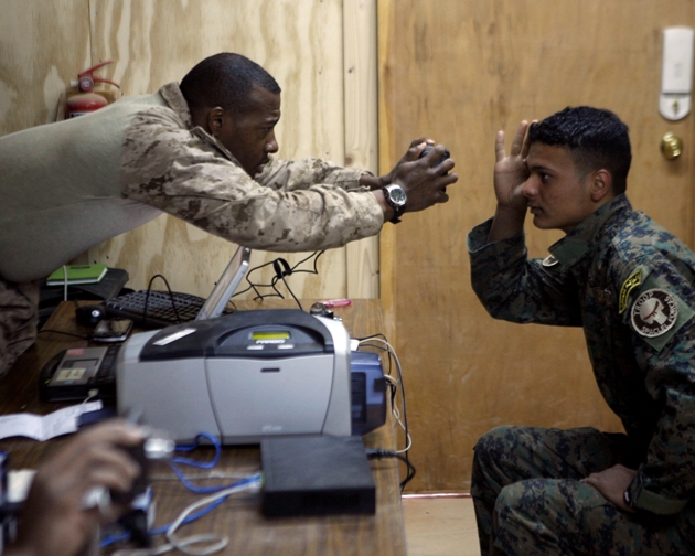 U.S. Marine Corps Master Sgt. Melvin Manor, serving with II Marine Headquarters Group Biometrics, II Marine Expeditionary Force (Forward), scans the right retina of an Iraqi soldier with the 7th Iraqi Army Division before creating an identification badge at Combat Outpost Nukayb in the Anbar province of Iraq March 20, 2009. (U.S. Marine Corps photo by Cpl. James F. Cline III/Released)