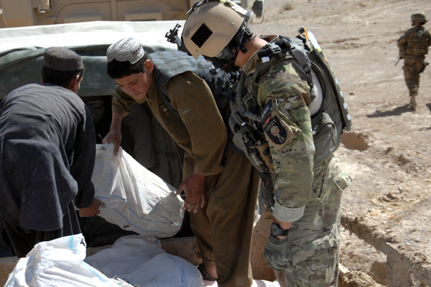 An Airman helps villagers unload supplies during a humanitarian aid mission recently. The Airmen delivered 5,000 pounds of goods and supplies to a local village. (U.S. Air Force photo/Master Sgt. Russell Martin)