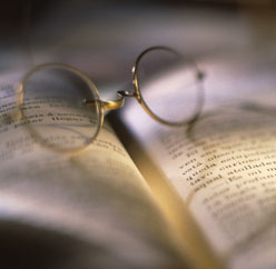 Open book with glasses on top.