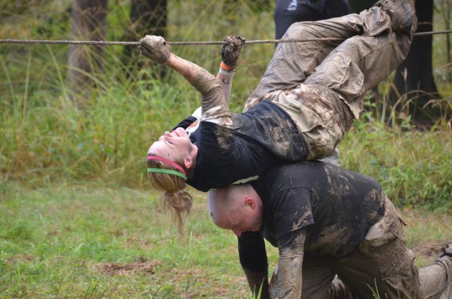Leah Luher makes her way across the rope pull with the help of her teammate Sgt. John White during the Spartan's Race, Sept. 28, 2012, on Warner Barracks near Bamberg, Germany. Faced with 10 grueling obstacles, the team of three spouses and one Soldier completed the race and earned themselves the Team Spirit award for their strong teamwork in helping each other complete the obstacles.