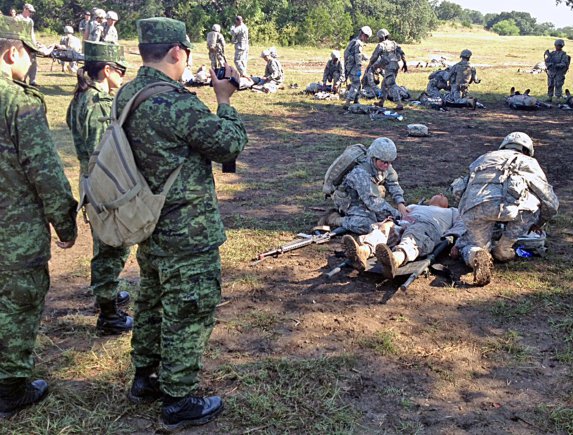 Mexican army medical officers observe basic level U.S. Army medical training being conducted at Camp Bullis, Texas, Sept. 19, 2012, as part of their visit with U.S. Army North during one of the stops of their visit to the United States. The officers are visiting to observe various levels of medical training at different Army facilities. The visiting Mexican army doctors became local heroes Sept. 19, after helping save a local San Antonian during dinner at the Tower of the Americas.