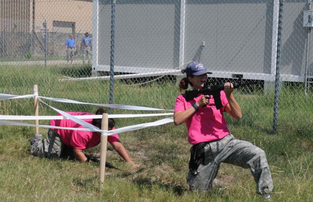 FORT HOOD, Texas--Ramona Walsh (right) and her fellow "battle buddy" navigate an obstacle course during a spouse spur ride here Sept. 7. Spouses completed simulated weapons training, a live-fire range, an obstacle course, and a simulated convoy live-fire before earning silver spurs.