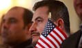 Man holding miniature U.S. flag (AP Images)