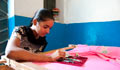 Zahida Bi embroidering sari (Courtesy of Woman’s World Banking)