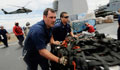 U.S. sailors pushing emergency supplies across the flight deck of a ship (U.S. Navy) 