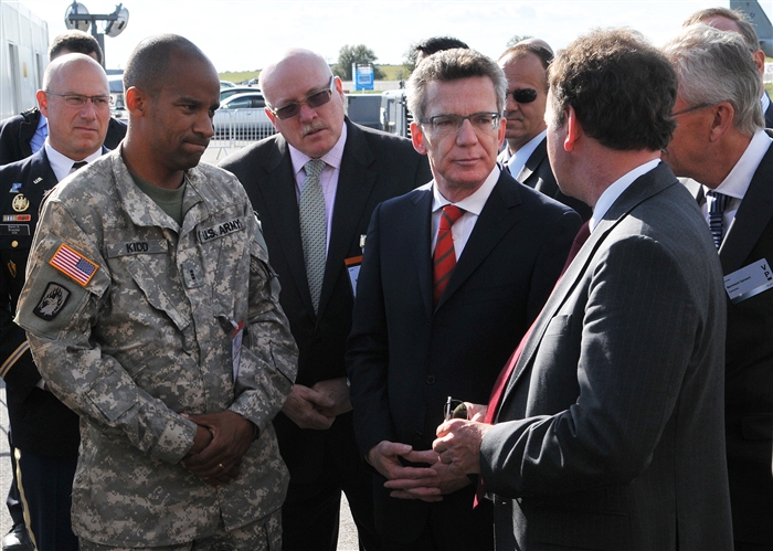 BERLIN - Thomas de Maiziere (center-left), German Defense Minister, and James Melville Jr. (center-right), U.S. Deputy Chief of Mission in Germany, receive a tour from Army Chief Warrant Officer 3 Andre Kidd, Joint Multinational Readiness Center Falcons UH-72A Lakota tactical officer, Hohenfels, Germany, during Berlin Air Show, commonly known as ILA 2012, here, Sept. 13, 2012. The air show is an international event hosted by Germany and more than 50 U.S. military personnel from bases in Europe and the United States are here to support the various U.S. military aircraft and equipment on display. The U.S. military aircraft featured at ILA 2012 are the UH-60 Black Hawk, UH-72A Lakota, F-16C Fighting Falcon, C-17 Globemaster III, and C-130 Hercules.