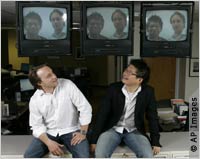 Two men looking at themselves on TV monitor (AP Images)