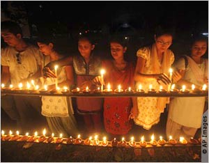 Женщины зажигают свечи  (AP Images)