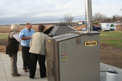 USDA Business & Cooperative Program Director Dana Kleinsasser(left), Area Specialist Darlene Bresson, and Legend Seeds President Glen Davis check out the biomass boiler system, which saves 60 percent of the cost of heating the seed company building, compared to the previous system.