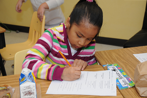 A student works hard on her assignment while eating a grab ‘n’ go breakfast in Mikelle Caine’s second grade advance class at Lake Forest Elementary School, Sandy Springs, Ga., (USDA photo by Debbie Smoot).