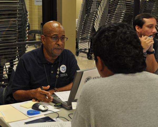 FEMA Applicant Assistant Andres Lugo answers questions for an applicant at the Hope Shelter DRC.