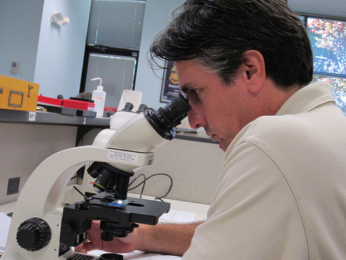 Basic Agricultural Safeguarding Training student with a microscope