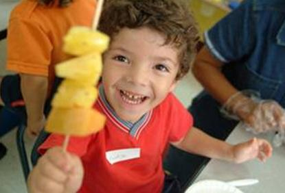 Un participante celebra con una piña durante un programa de Salsa, Sabor y Salud. 