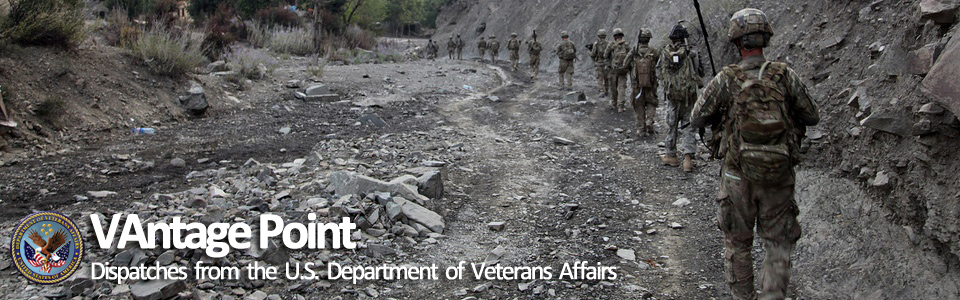 Army soldiers wearing digital camouflage are walking along a mountain road on patrol in Afghanistan.