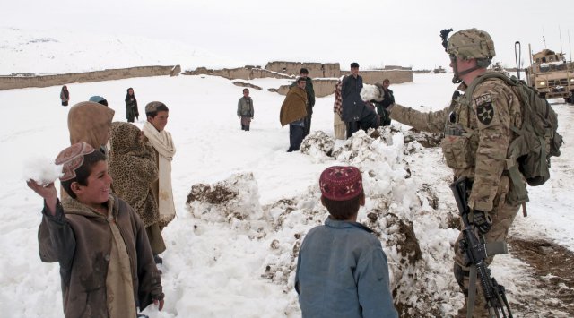 Sgt. Robert Logue, Battle Company, 5th Battalion 20th Infantry Regiment, Task Force 1st Squadron 14th Cavalry Regiment, tosses snowballs back and forth with some of the children from the village of Meden Kheyl, Feb. 19, 2012. Battle Company partnered with the Afghan National Army to help clear the roads from Forward Operating Base Sweeney to the villages of Menden Kheyl and Shinkai, following 3 days of snow, allowing residents from the area to reach the Shinkai Bazaar.