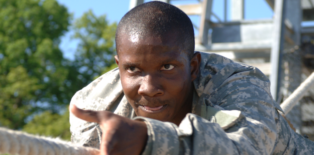 Soldier sliding down the inverted rope obstacle 