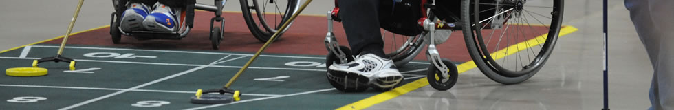 People in wheelchairs playing shuffleboard.