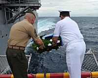 Sgt. Maj. Scott Pile, left, assigned to the 11th Marine Expeditionary Unit (11th MEU), and Master Chief Steven Alt, the command master chief of the amphibious assault ship USS Makin Island (LHD 8), participate in a wreath laying ceremony.