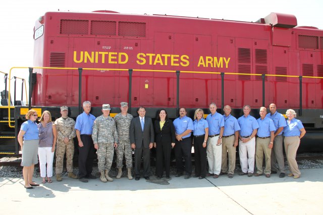 Gen. Martin E. Dempsey, chairman of the Joint Chiefs of Staff, and Katherine Hammack, assistant secretary of the Army for installations, energy and environment, pose for a group photo with the men and women of Tooele Army Depot, Utah, in front of the Army Depot's locomotive engines. Dempsey and Hammack congratulate the men and women, who for 70 years have provided readiness and rapid munitions response to America's allies and war fighters worldwide.
