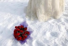 A bouquet is seen in the snow as a bride poses for a photograph after a group wedding ceremony during the 26th Harbin International Ice and Snow Festival in Harbin, Heilongjiang province January 6, 2010. REUTERS/Aly Song